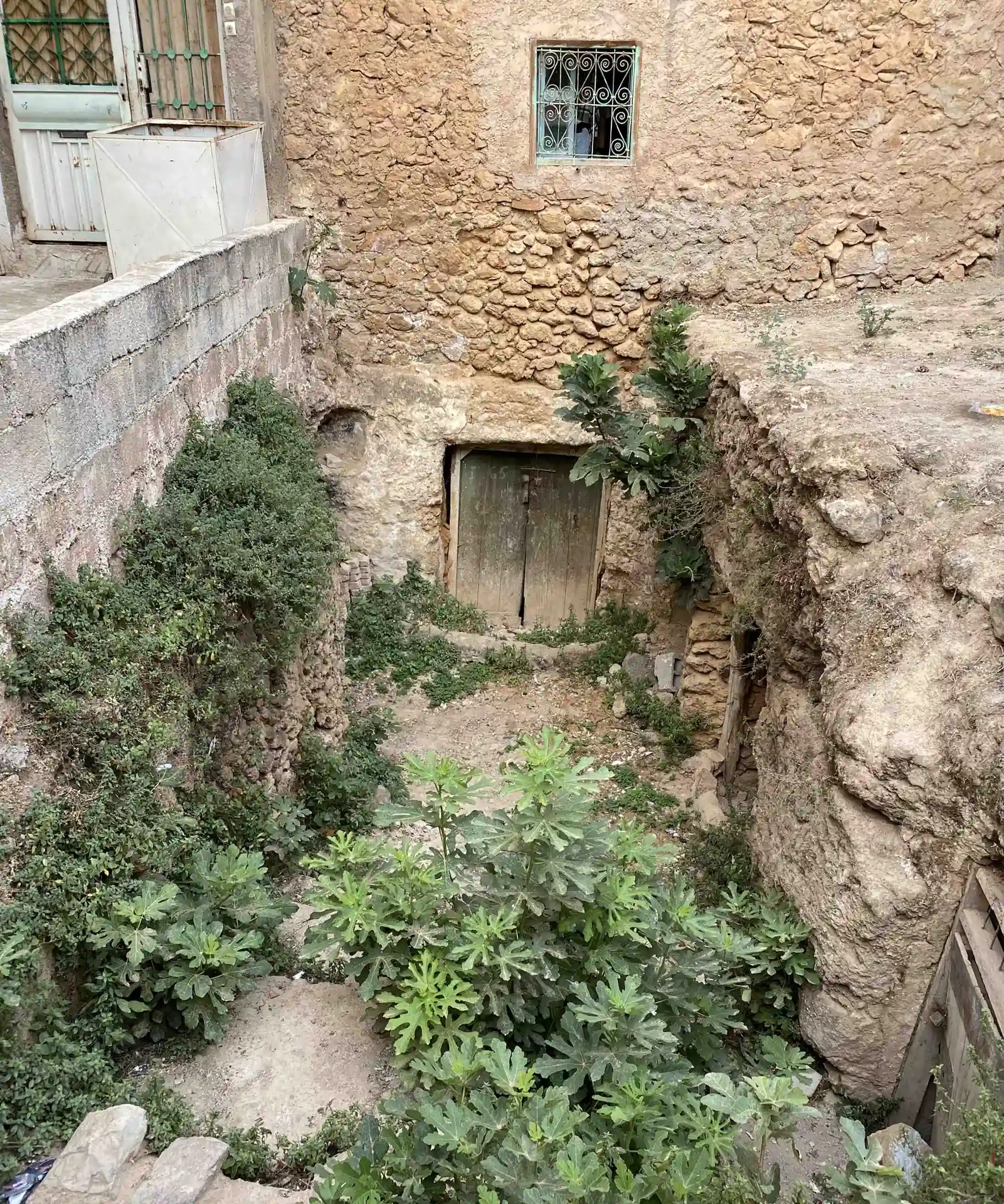 Rock-cut doorway beneath a traditional house in Bhalil