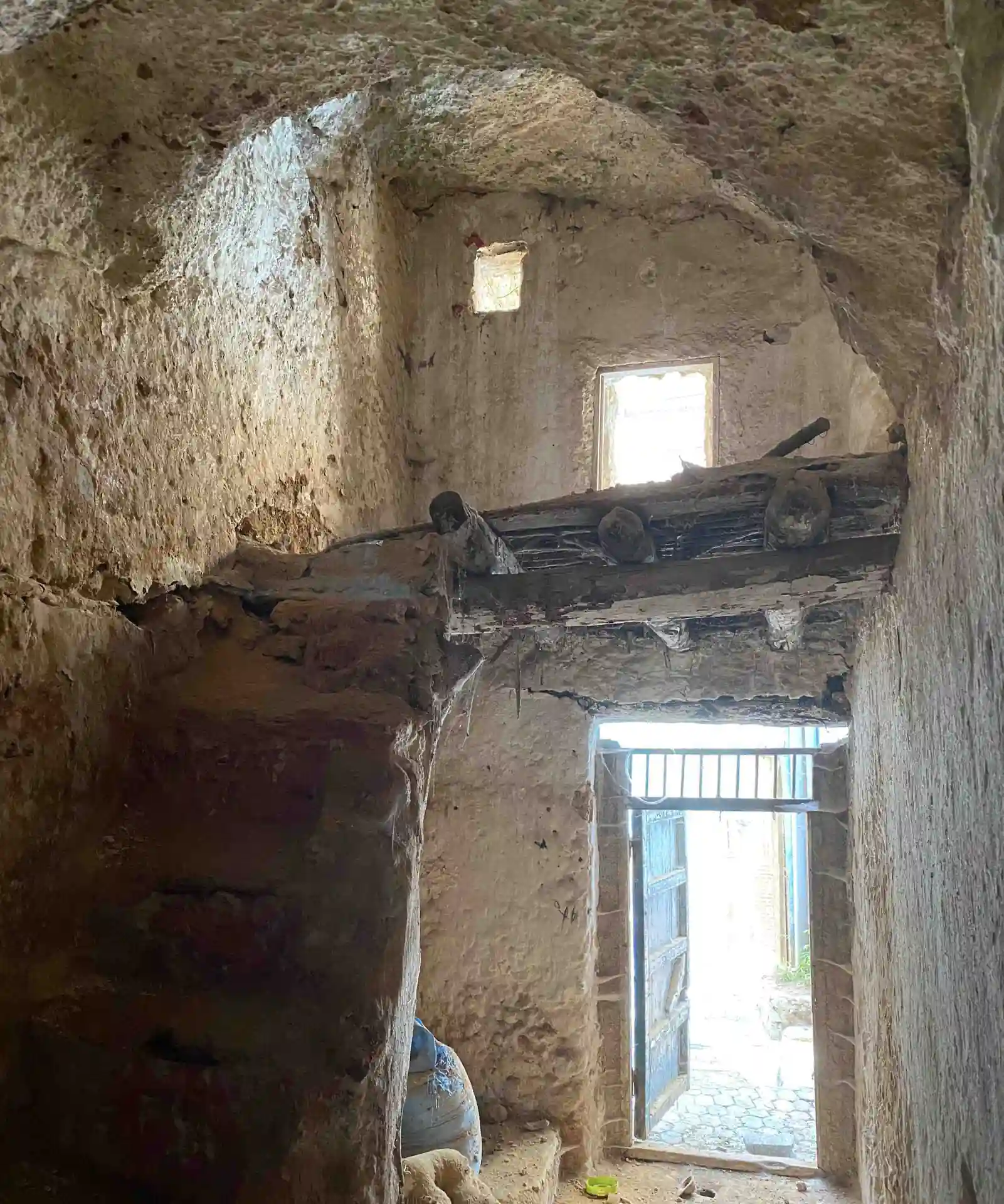 Alto ambiente in grotta non rifinito, con soppalco in legno e aperture per la luce naturale