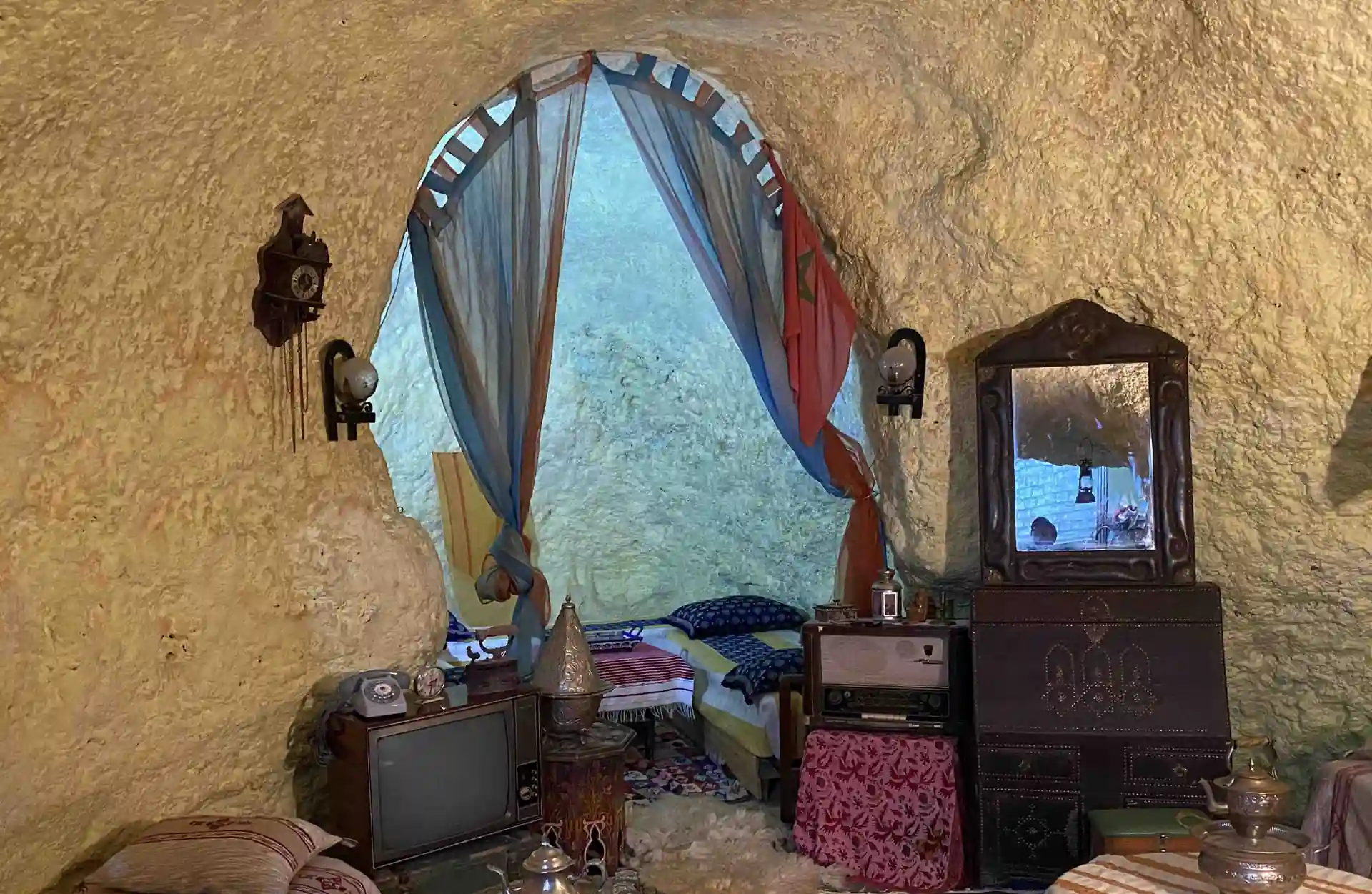 Ambiente in grotta con apertura ad arco, mobili tradizionali e oggetti domestici d'epoca