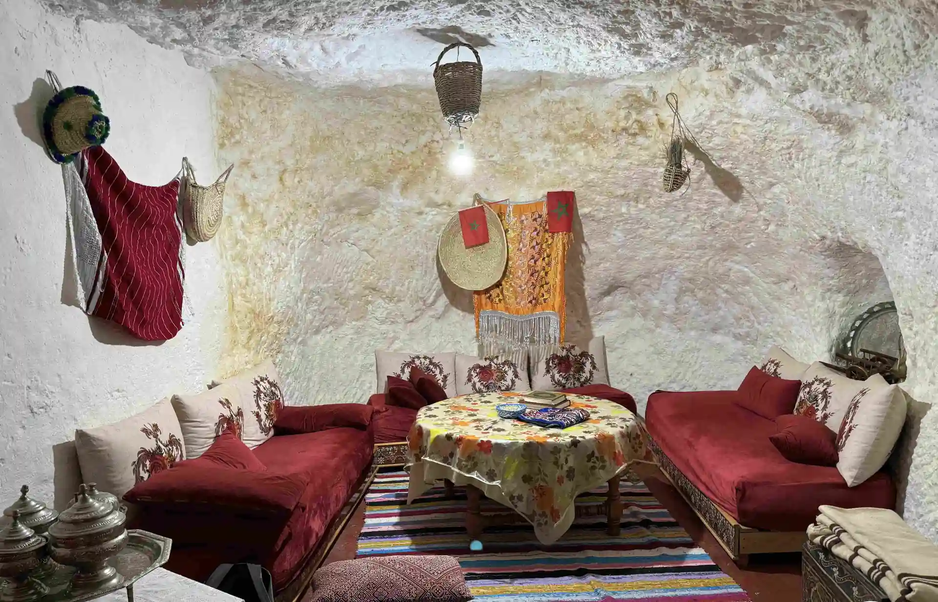 Furnished white rock-cut sitting room inside a Bhalil cave home