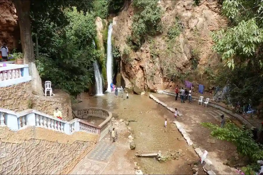 The Sefrou waterfalls in a green gorge with visitors, Morocco