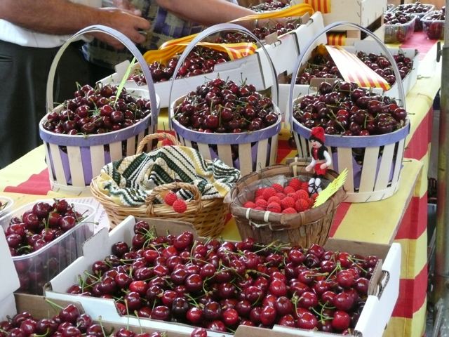 Baskets and boxes of fresh cherries displayed at the Sefrou Cherry Festival market