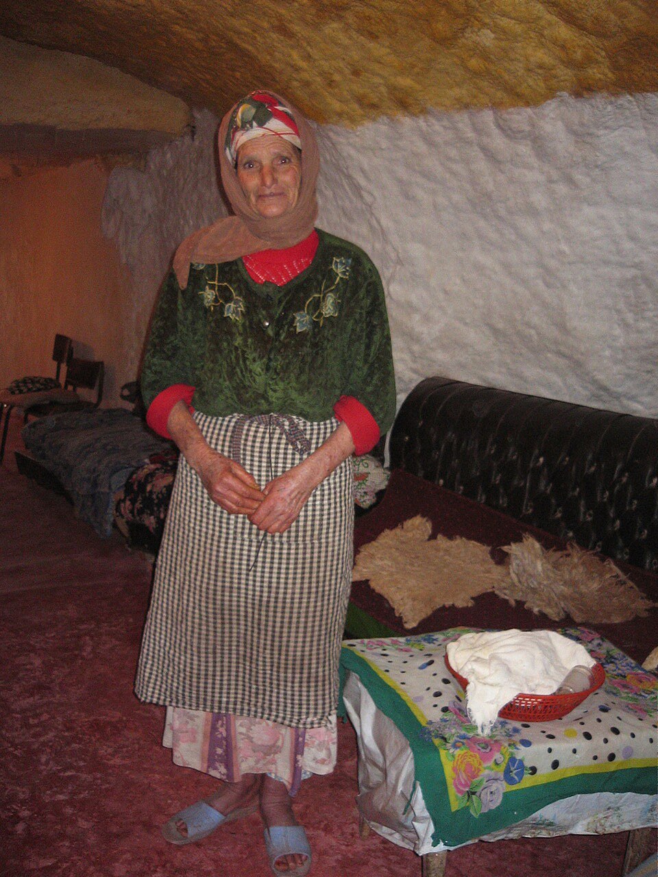 Bhalil resident standing inside her family's rock-cut home