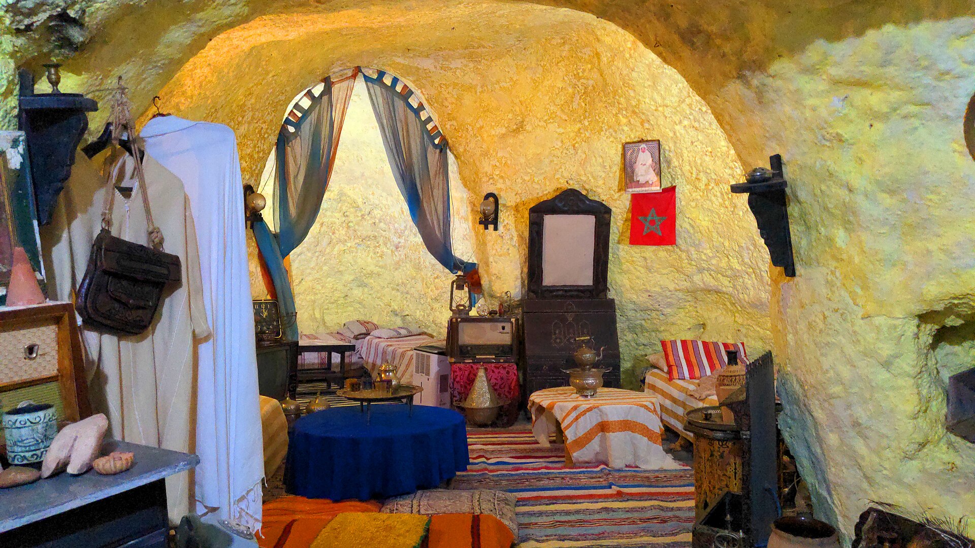 Traditional furnished sitting and sleeping room carved into rock in Bhalil