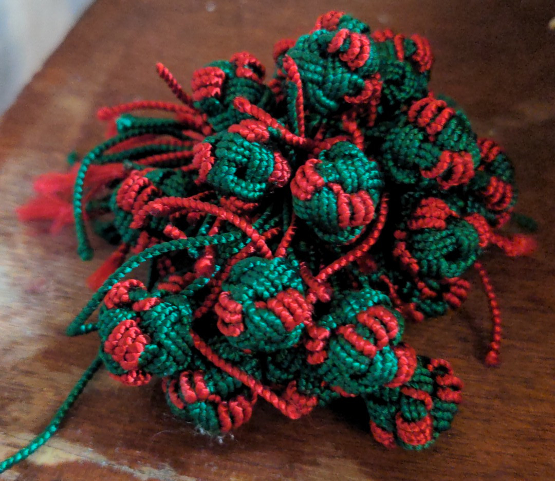 Hand-knotted red and green silk buttons made for traditional djellabas near Sefrou